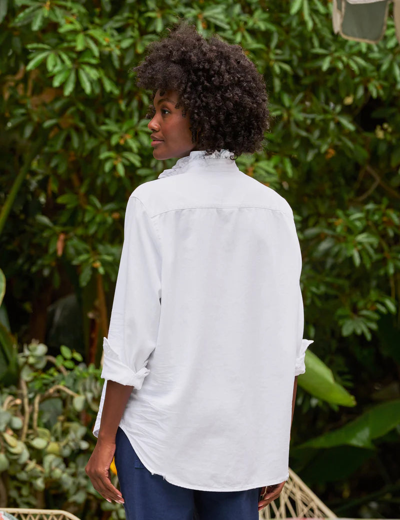 woman wearing Frank & Eileen Eileen Ruffle in White standing outdoors with greenery in the background backview