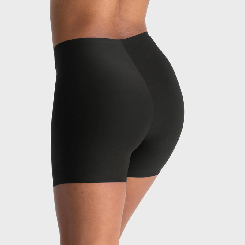 woman wearing a gray hoodie and Evelyn & Bobbie Longline Girlshort/Slip Short in Black against a white background backview