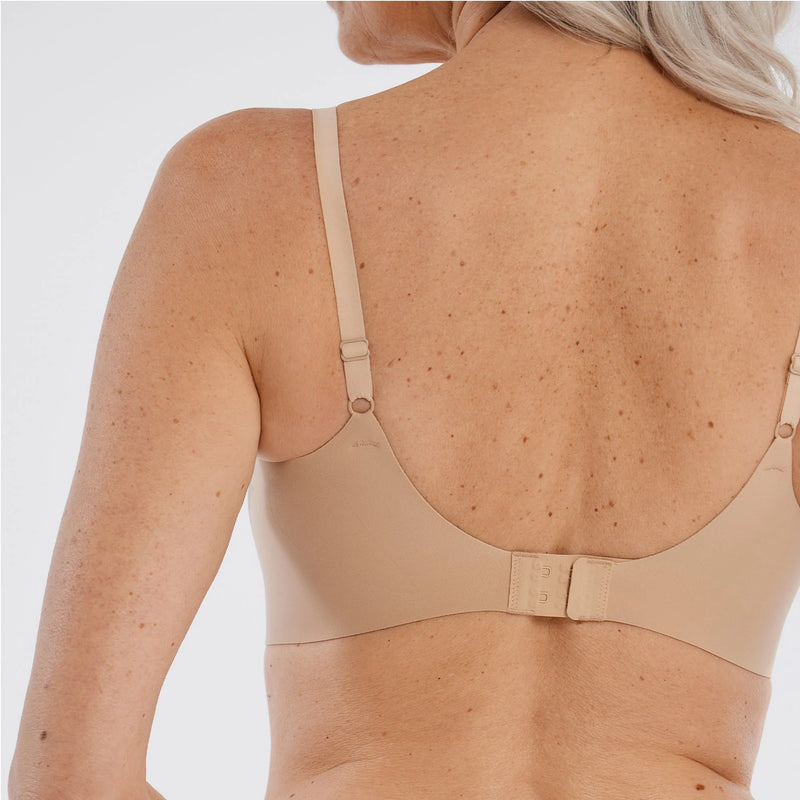 Woman wearing Evelyn & Bobbie Starlette Plunge Bra in Sand against a plain background backview