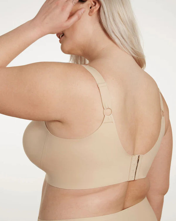 Woman wearing Evelyn & Bobbie Beyond Bra in Sand against a white background backview