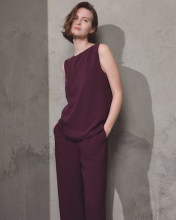 woman wearing Lamberto Losani Sleeveless Crewneck Shell in Aubergine against grey wall well heeled vt