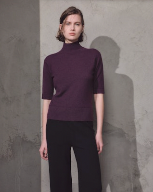 woman wearing Lamberto Losani Mockneck Half Sleeve in Aubergine against grey wall well heeled vt