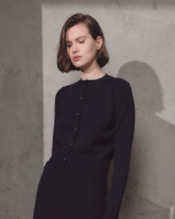 woman wearing Lamberto Losani Mini Cardigan in Black against grey wall