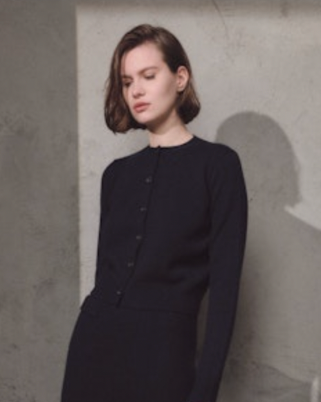 woman wearing Lamberto Losani Mini Cardigan in Black against grey wall