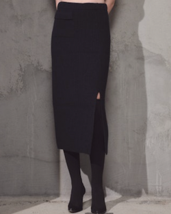 woman wearing Lamberto Losani Long Skirt in Dark Blue against grey wall