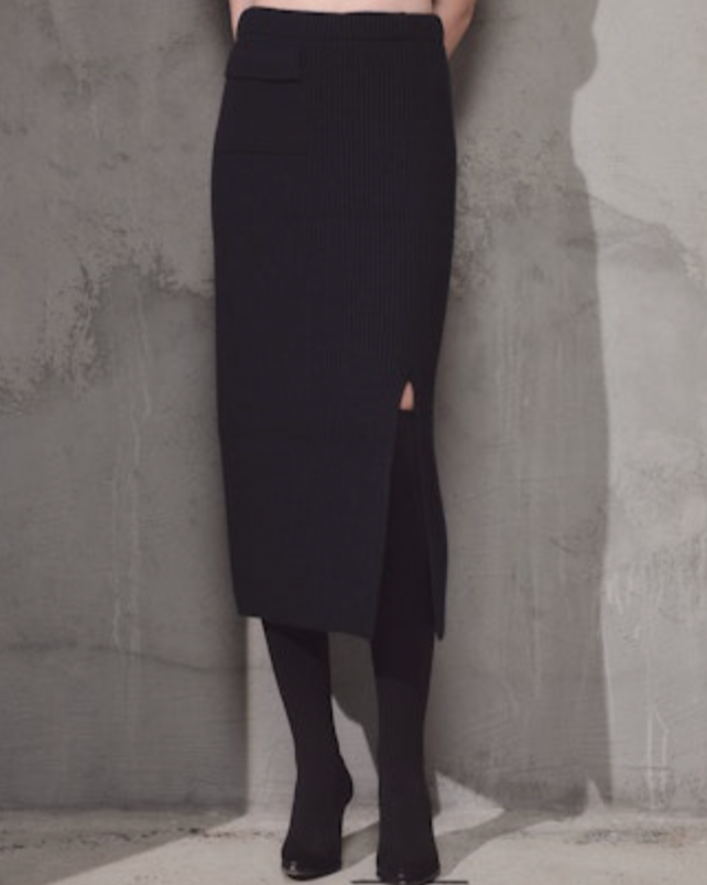 woman wearing Lamberto Losani Long Skirt in Dark Blue against grey wall