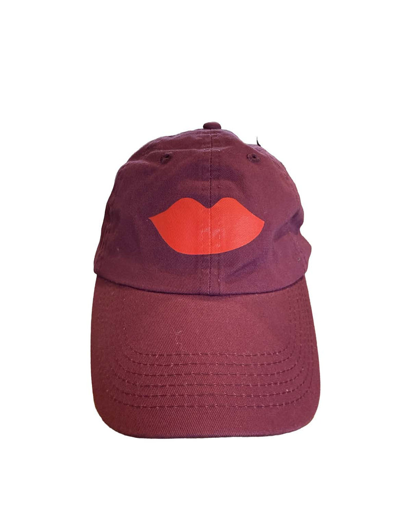 clare v oxblood cap with red lips design on a white background